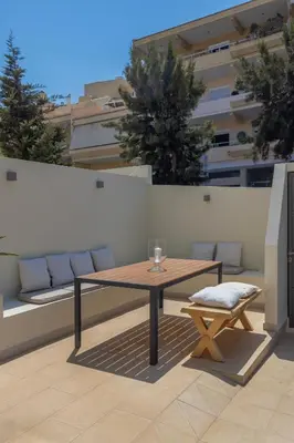 a wooden table and a chair on a patio at Luxury in Simplicity , Nature's Touch , Mezzanine in Rhodes Town