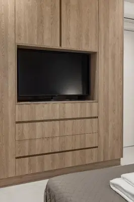 a wooden entertainment center with a flat screen tv at Luxury in Simplicity , Nature's Touch , Mezzanine in Rhodes Town