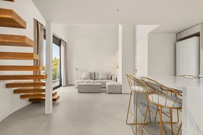 a white living room with a staircase and chairs at Luxury in Simplicity , Nature's Touch , Mezzanine in Rhodes Town
