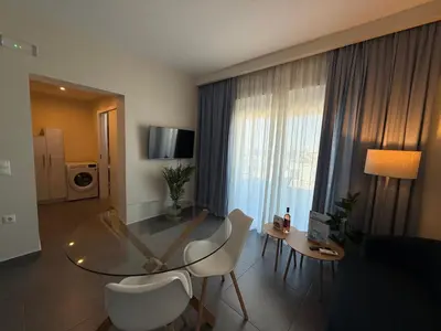 a living room with a glass table and chairs at Arfaras Home in Ixia