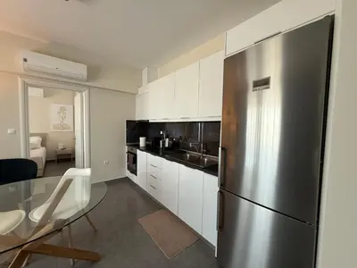 a kitchen with a stainless steel refrigerator and white cabinets at Arfaras Home in Ixia