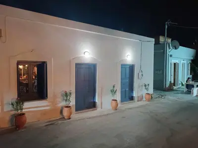 a white building with blue doors and potted plants at La Stella studio in Livadia