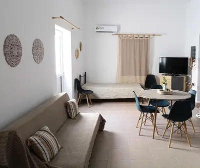 a living room with a couch and a table at La Stella studio in Livadia