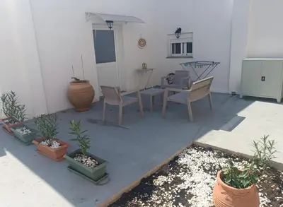 a patio with a table and chairs and potted plants at La Stella studio in Livadia