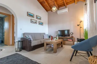 a living room with a couch and a tv at Ampeli Villa in Kolimbia