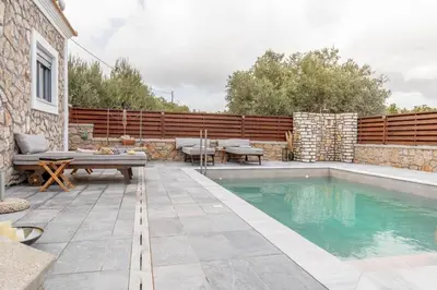 a backyard with a swimming pool and a wooden fence at Ampeli Villa in Kolimbia