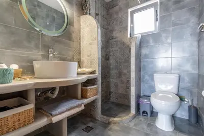 a bathroom with a sink and a toilet at Ampeli Villa in Kolimbia