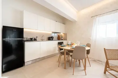a kitchen with a table and a black refrigerator at Spiti Apartment Ialysos in Ialyssos