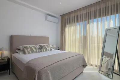 a bedroom with a bed and a large window at Villa Galini in Haraki