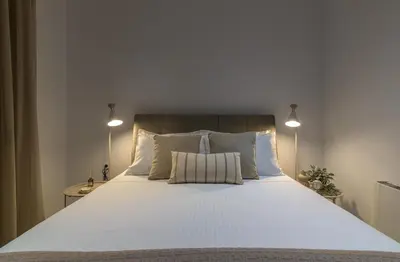 a large white bed with two pillows and two lamps at Villa Galini in Haraki