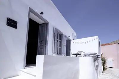 a white building with a door and a table at Mea Casa Halki in Halki