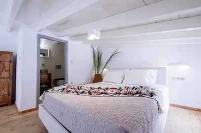 a white bedroom with a large bed in a room at Mea Casa Halki in Halki