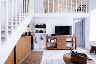 a living room with a staircase and a television at Mea Casa Halki in Halki