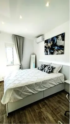 a bedroom with a large bed with white sheets at Angelica Residence in Gennadi