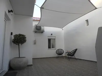 a white room with a potted tree and two chairs at Angelica Residence in Gennadi