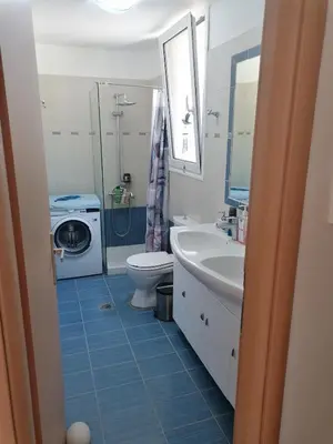 a bathroom with a sink toilet and a washing machine at Villa Klelia in Afantou
