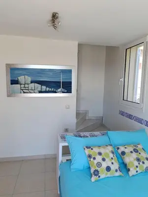 a bedroom with a blue bed and a window at Villa Klelia in Afantou