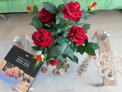 a vase filled with red roses sitting on a table at Villa Klelia in Afantou