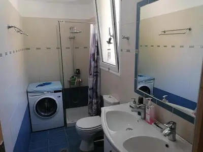 a bathroom with a washing machine and a washer at Villa Klelia in Afantou