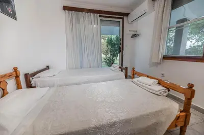 two beds in a room with a window at Villa Hara Kiotari in Gennadi