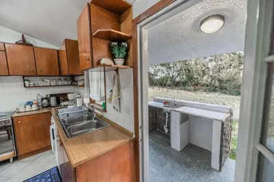 a kitchen with wooden cabinets and a sink and a window at Villa Hara Kiotari in Gennadi
