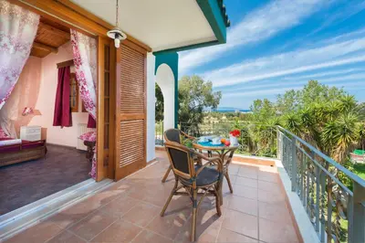a patio with a table and chairs on a balcony at Villas Marianna in Kalavárda