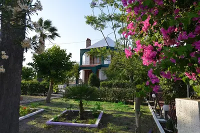 a house with trees and flowers in front of it at Villas Marianna in Kalavárda