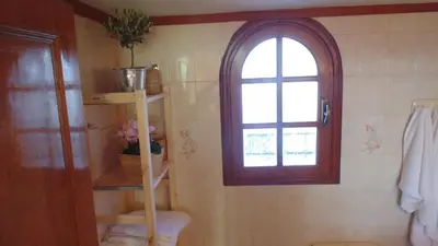 a bathroom with a book shelf and a window at Villas Marianna in Kalavárda