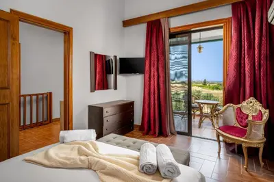 a bedroom with a bed and a view of the ocean at Villas Marianna in Kalavárda