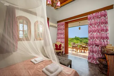a bedroom with a bed with a mosquito net at Villas Marianna in Kalavárda