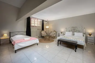 a bedroom with two beds and a table and a chair at Villas Marianna in Kalavárda