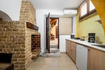 a kitchen with a brick fireplace next to a counter at Muses-Old Town in Rhodes Town