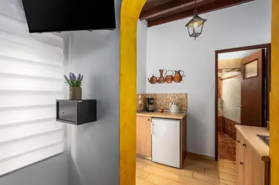 a kitchen with white walls and a yellow pole at Muses-Old Town in Rhodes Town