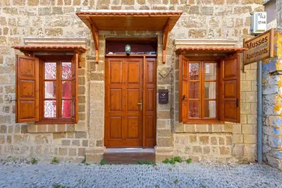 a building with a wooden door and two windows at Muses-Old Town in Rhodes Town