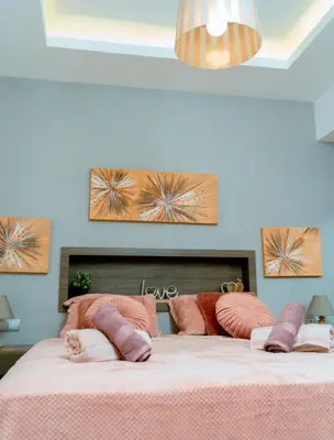a bedroom with a bed with pink sheets and pink pillows at Filoxenia City Escape in Rhodes Town
