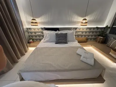 a bedroom with a large bed with two towels on it at Agathi Beauty Studios in Haraki