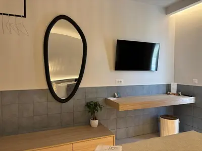 a bathroom with a mirror and a tv on the wall at Agathi Beauty Studios in Haraki