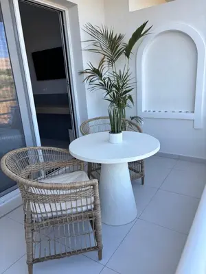a table and chairs with a potted plant on a balcony at Agathi Beauty Studios in Haraki