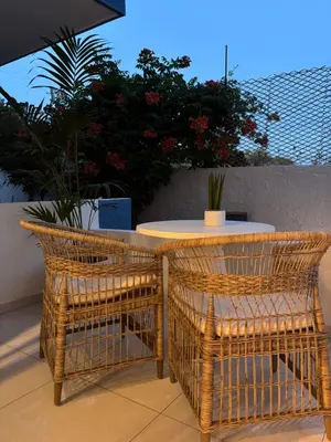 two wicker chairs and a table on a patio at Agathi Beauty Studios in Haraki