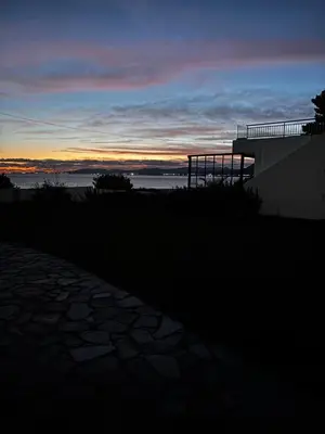a sunset over the ocean with a building at Amphora Sea View Pefkos in Pefki Rhodes