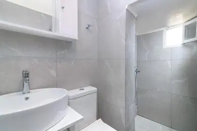 a bathroom with a toilet and a sink and a shower at Kyramarias Village house in Malona Village
