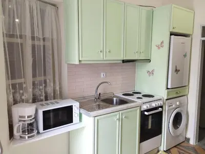a kitchen with green cabinets and a sink and a microwave at Kyramarias Village house in Malona Village