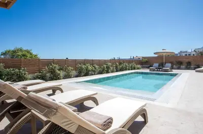 a swimming pool with chaise lounge chairs next to a swimming pool at Aeon Rhodes - New Villa with private pool in Rhodes Town
