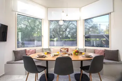 a dining room with a table and chairs and windows at Aeon Rhodes - New Villa with private pool in Rhodes Town