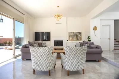 a living room with a couch and a table and chairs at Aeon Rhodes - New Villa with private pool in Rhodes Town