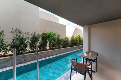 a swimming pool with a table and chairs next to a building at Alizo Comfort Chic Stay Rhodes - Adults Only in Ixia