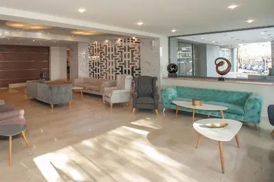a lobby with a blue couch and chairs and tables at Rhodos Horizon Marina - Adults Only in Rhodes Town