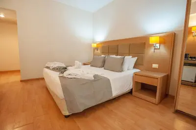 a bedroom with a large bed with white sheets at Rhodos Horizon Marina - Adults Only in Rhodes Town