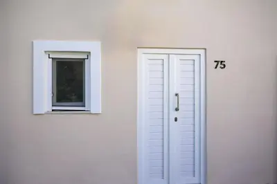 a white door and a window on a white wall at Kiki House in Rhodes Town