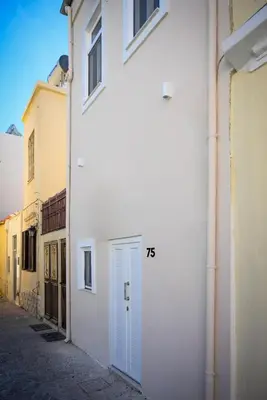 a white building with a blue door on a street at Kiki House in Rhodes Town